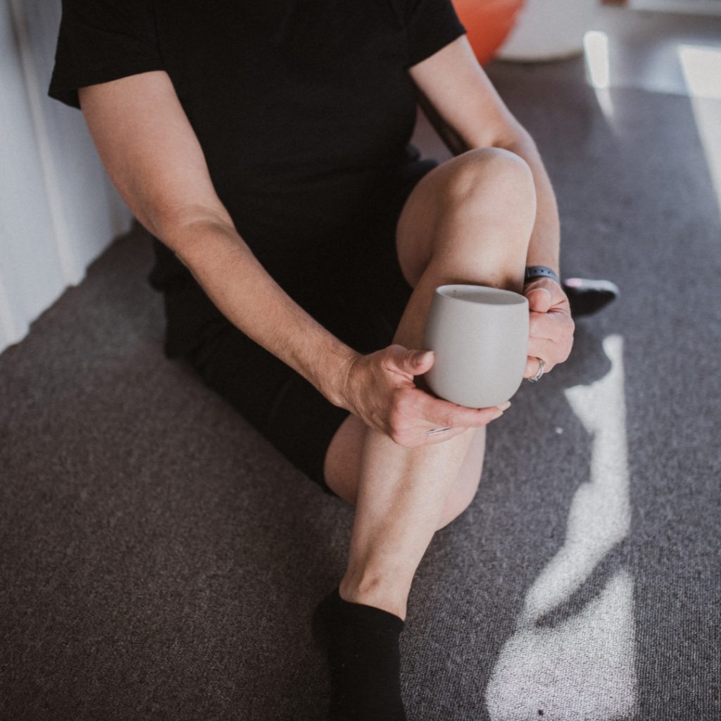 Woman sitting cross legged holding mug